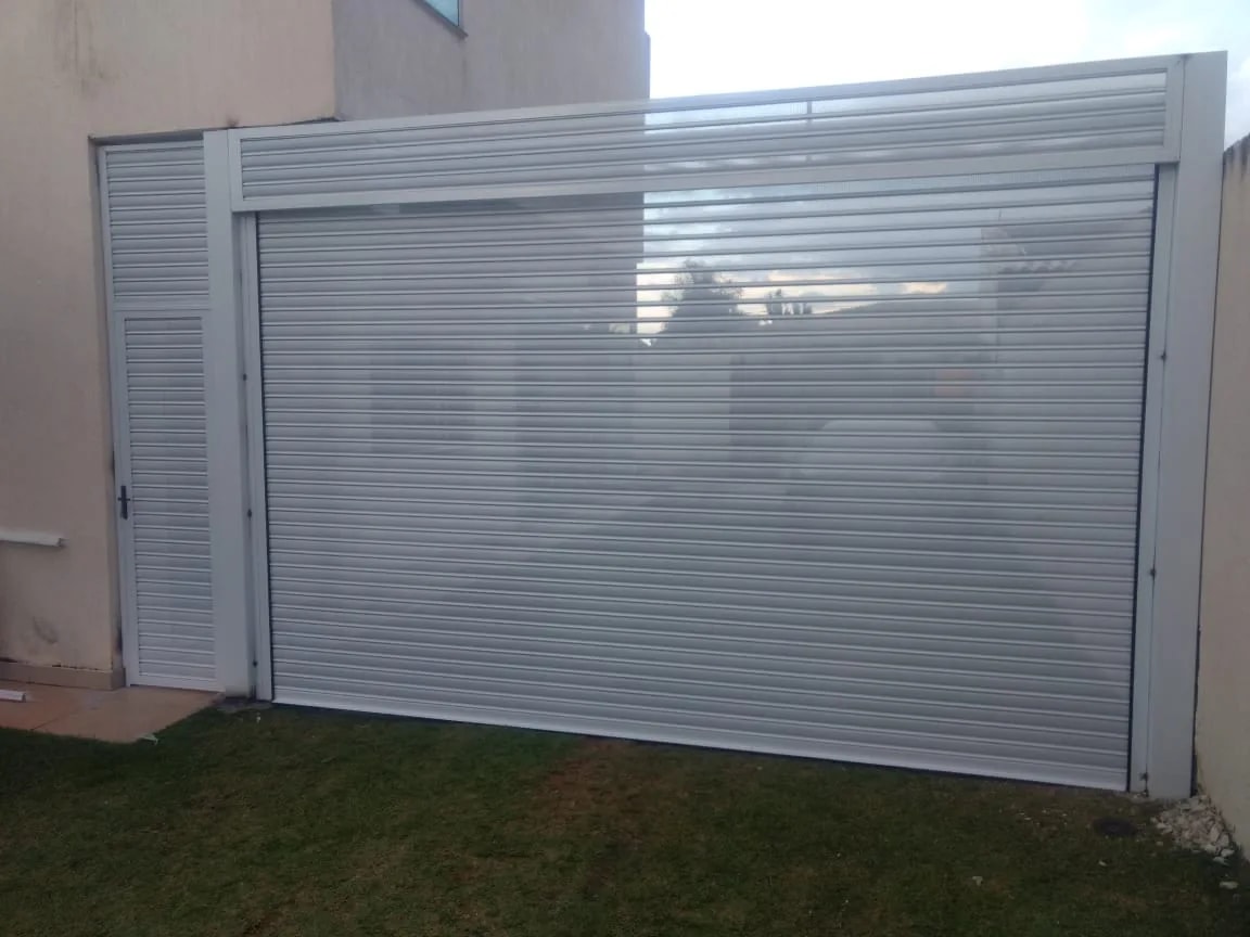 Fachada residencial de alto padrão com porta de enrolar